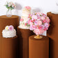 Cinnamon brown stretchable pedestal stand covers with decorative floral arrangements.