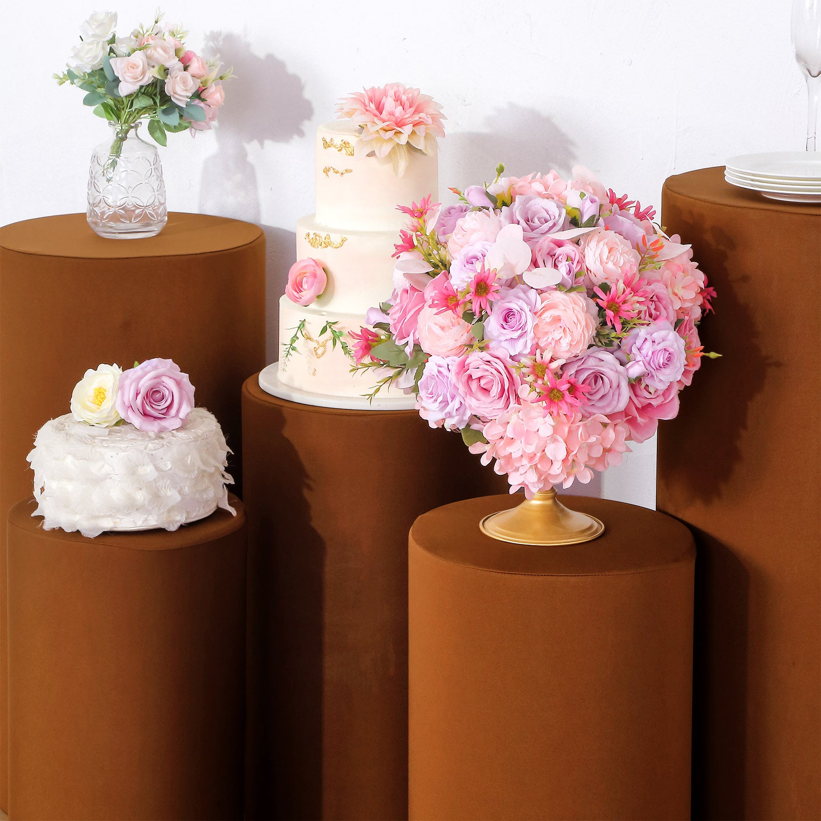 Cinnamon brown stretchable pedestal stand covers with decorative floral arrangements.