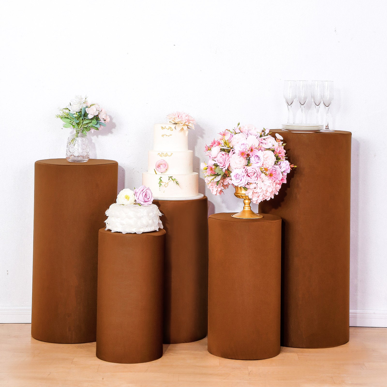 Cinnamon brown spandex pedestal stand covers for stylish event displays.
