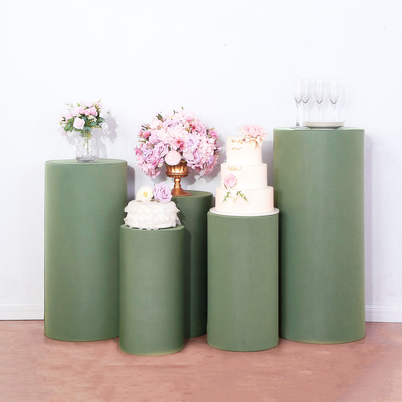 Dusty sage green spandex pedestal stand covers for events and displays.