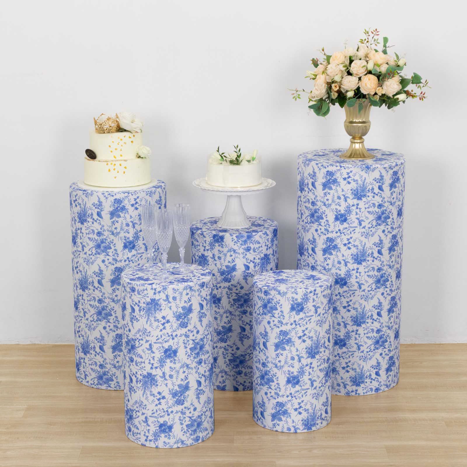 White and blue floral spandex pedestal stand covers set on display.