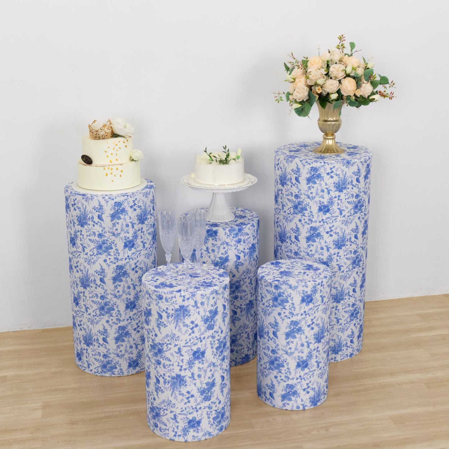 White and blue spandex pedestal stand covers in French toile floral pattern.