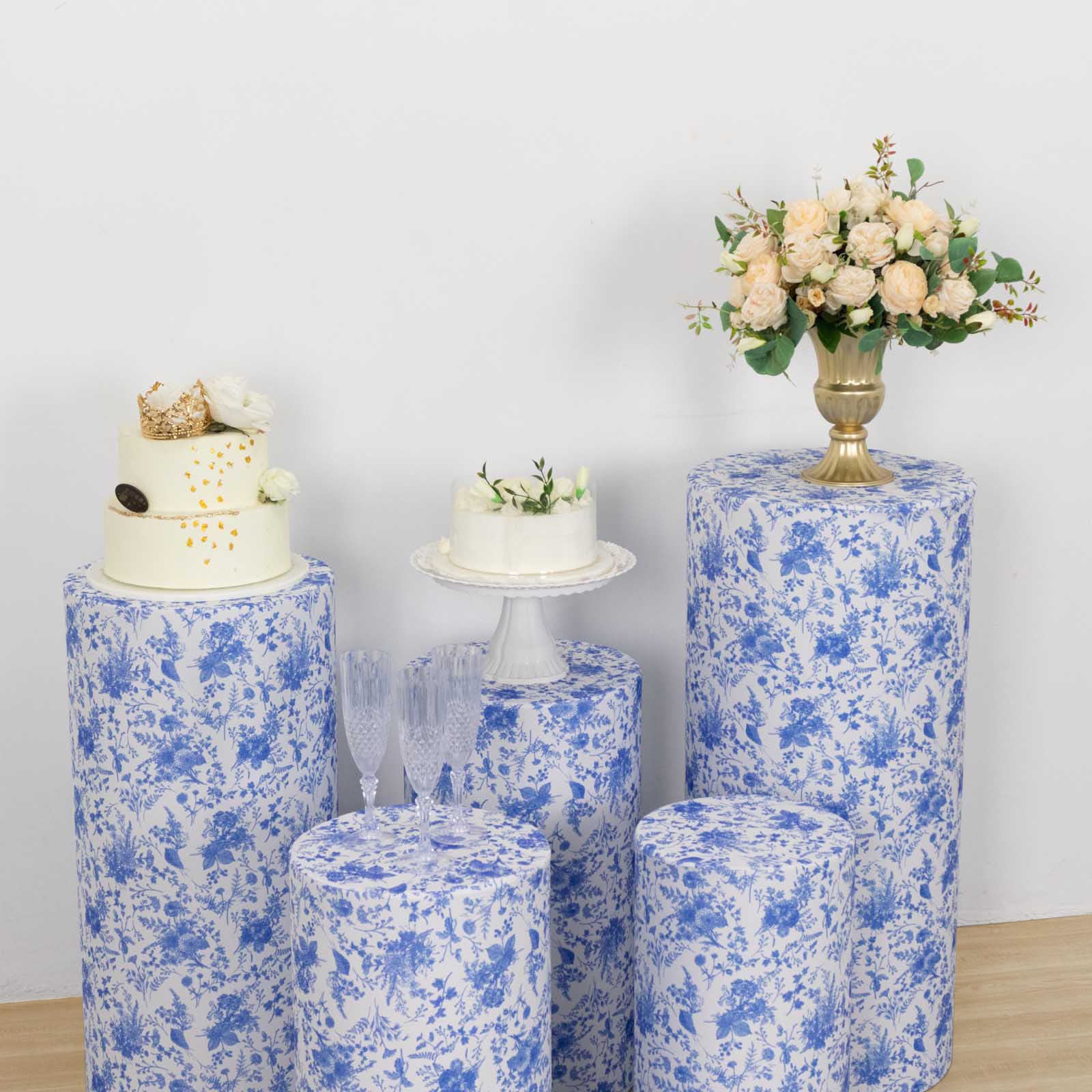 White and blue spandex pedestal stand covers with floral pattern.