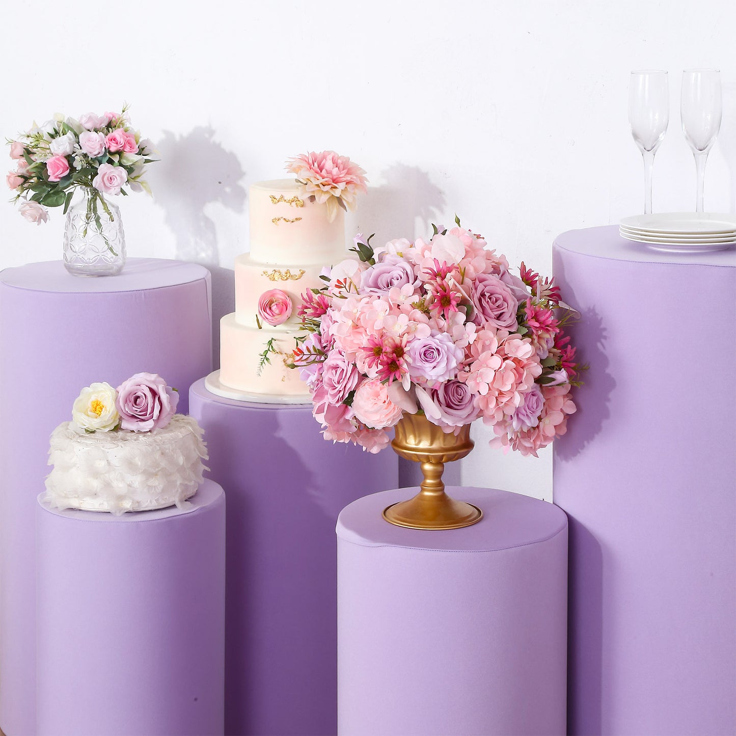 Lavender lilac spandex pedestal stand covers in a floral setting.