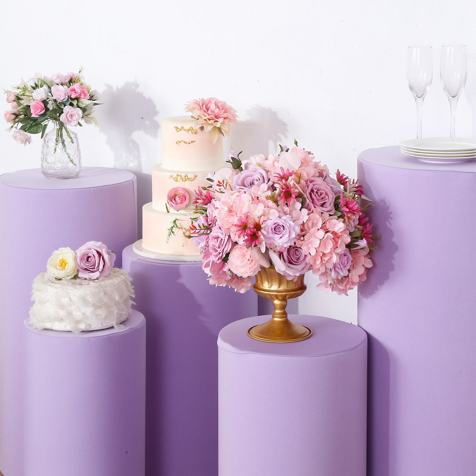 Lavender lilac spandex pedestal stand covers in a floral setting.