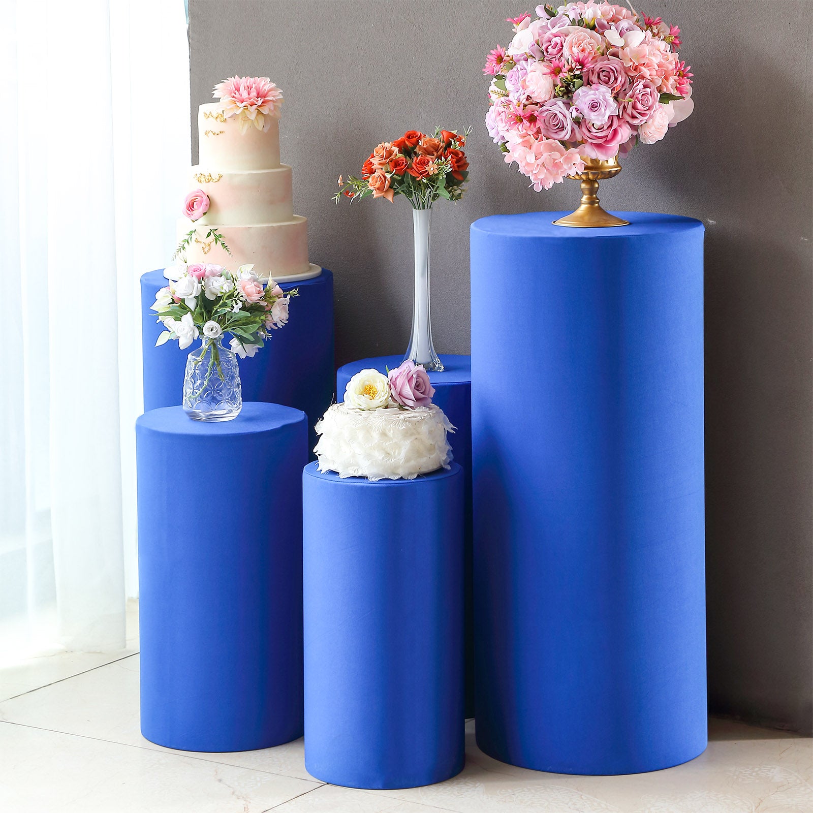 Royal blue spandex pedestal stand covers for elegant event displays.