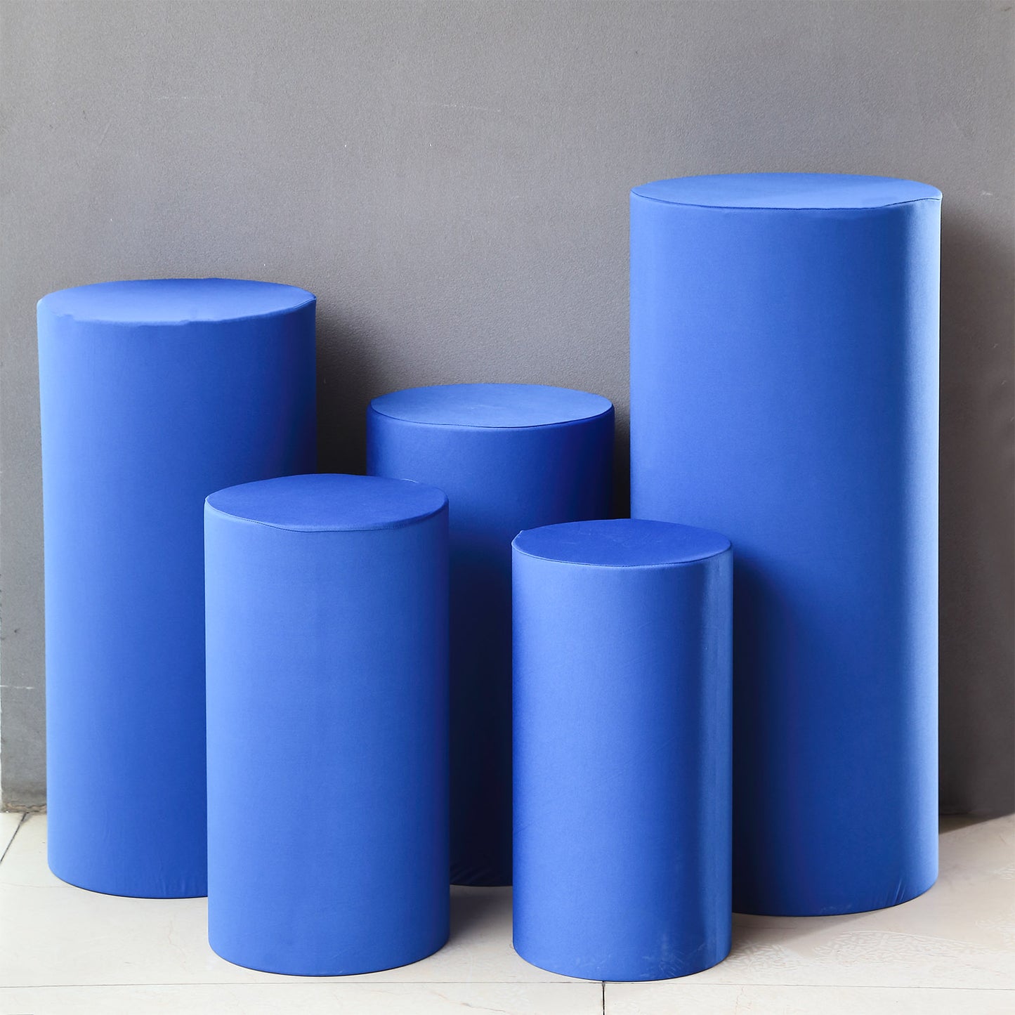 Set of 5 royal blue spandex cylinder pedestal stand covers.