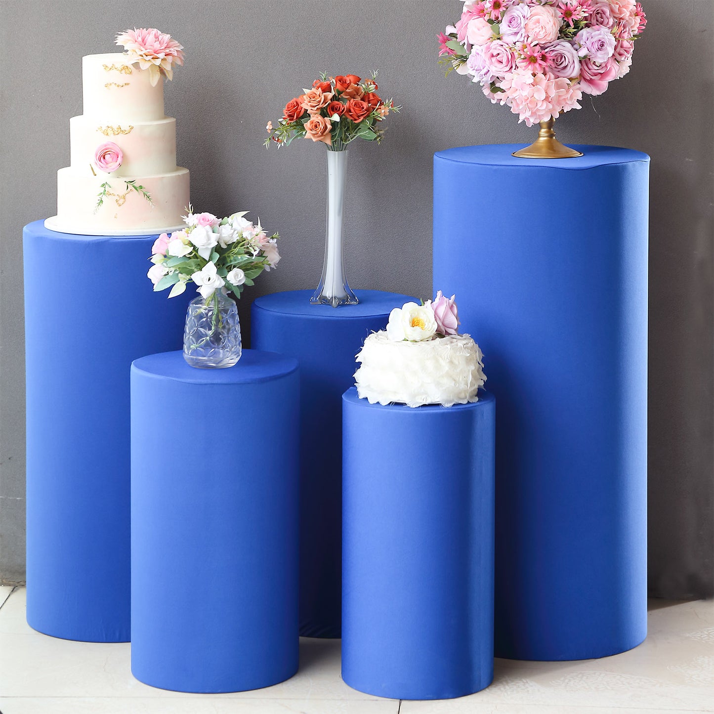 Set of 5 royal blue spandex pedestal stand covers for events.