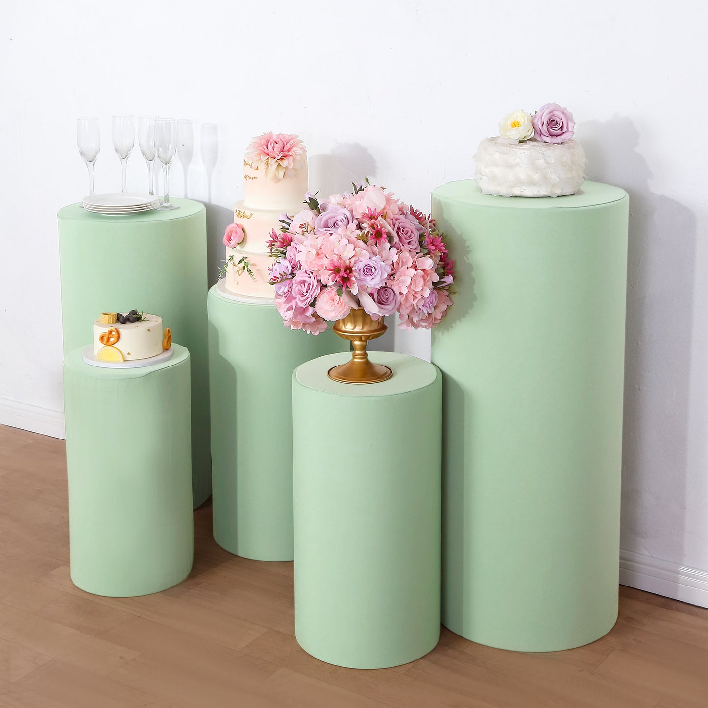 Sage green spandex pedestal stand covers for events and displays.