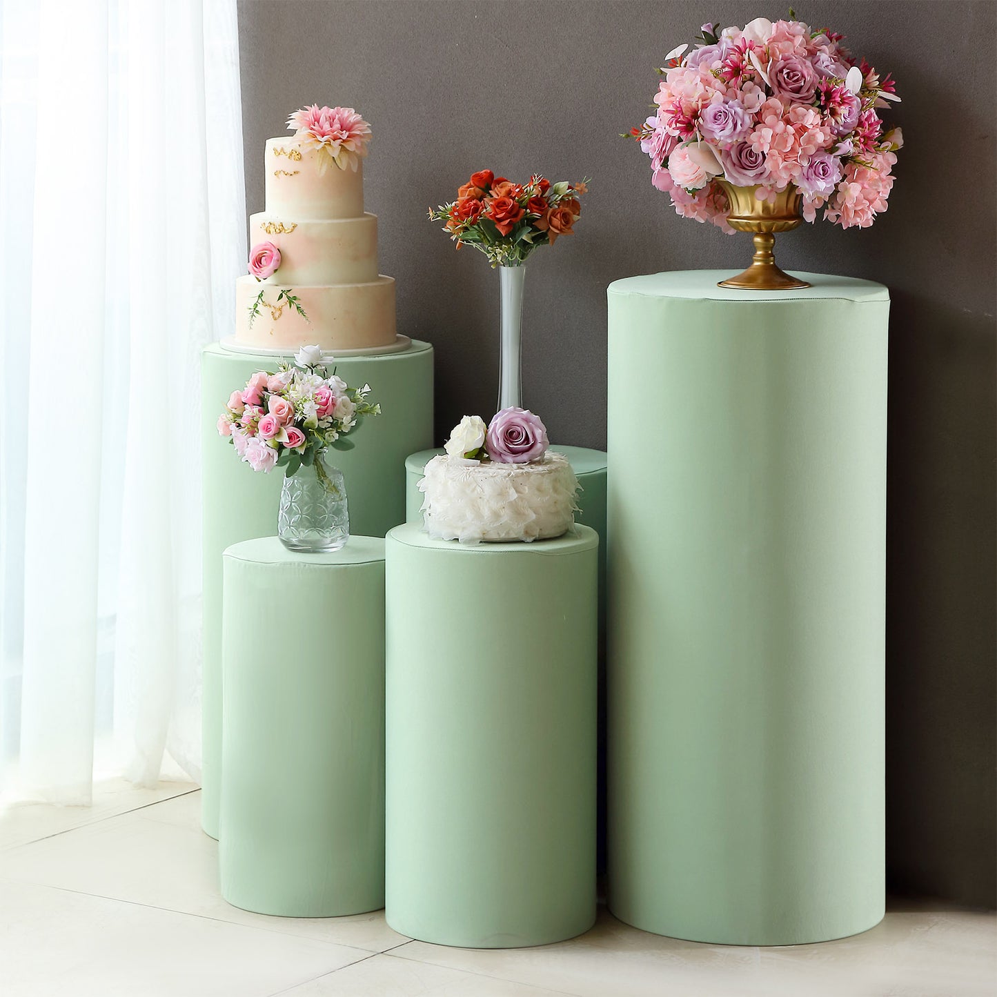 Sage green spandex pedestal stand covers for event decoration.