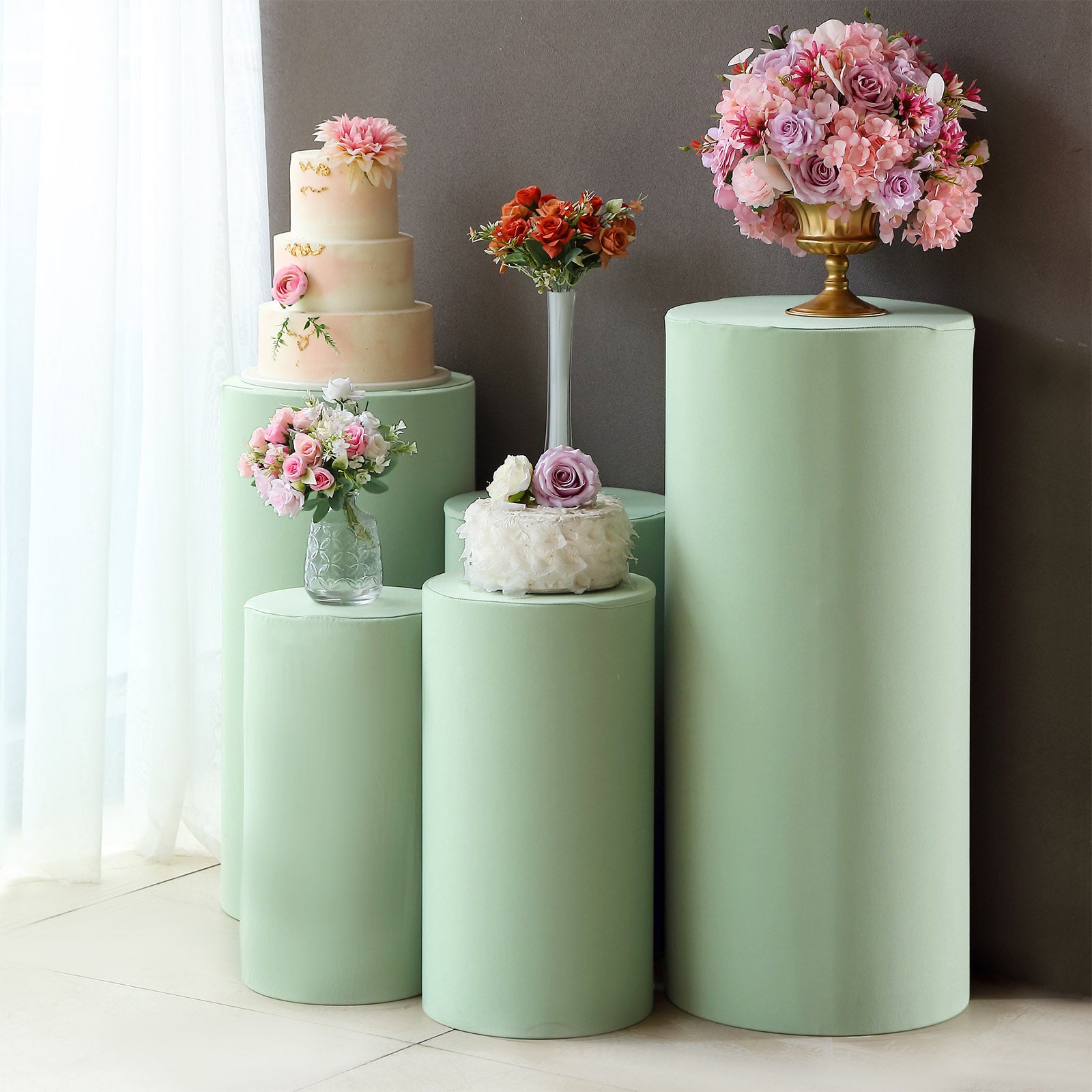 Sage green spandex pedestal stand covers for event decoration.
