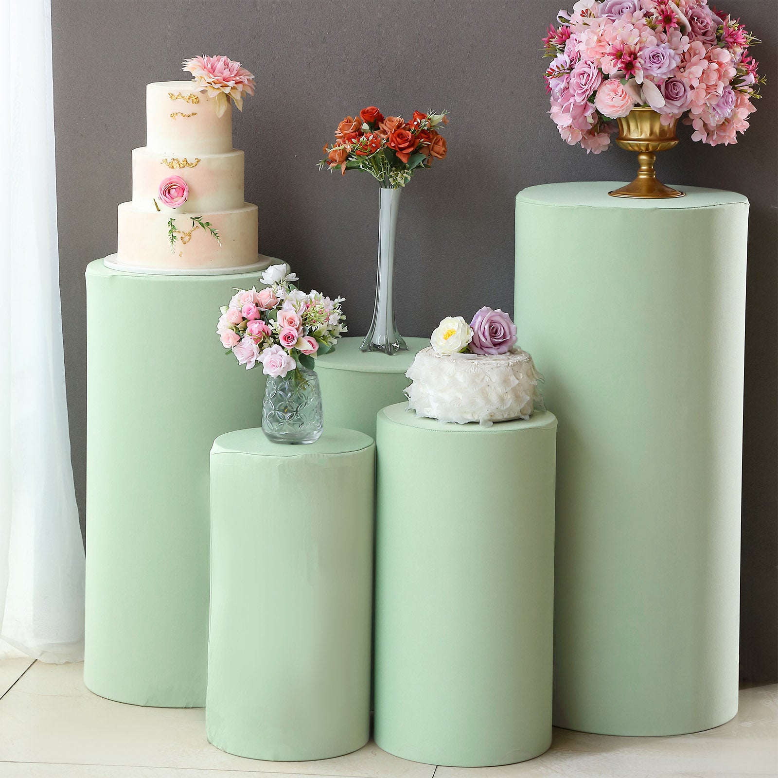 Sage green spandex pedestal stand covers for events and decor.