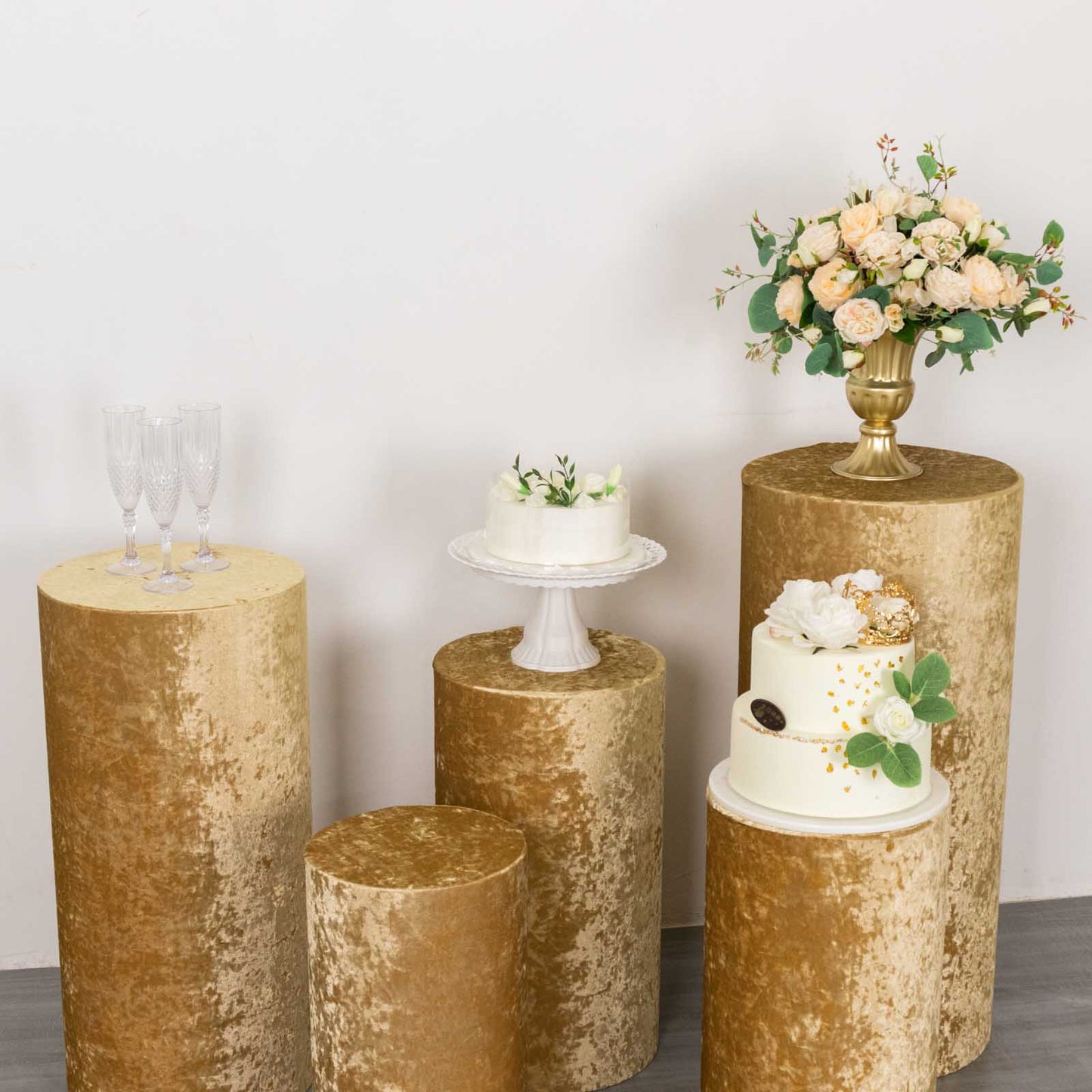 Champagne velvet pedestal stand covers for events and displays.
