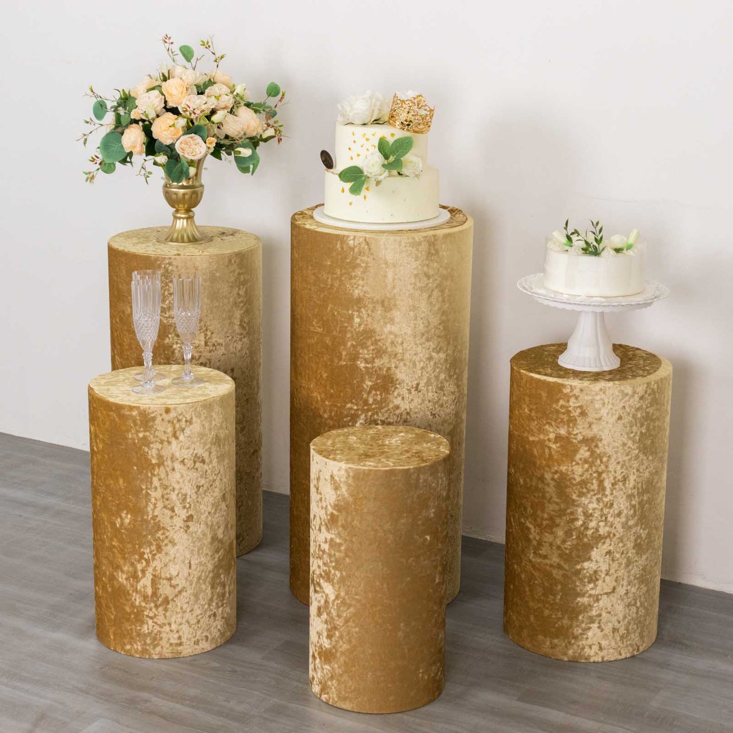 Champagne velvet pedestal stand covers for elegant displays.