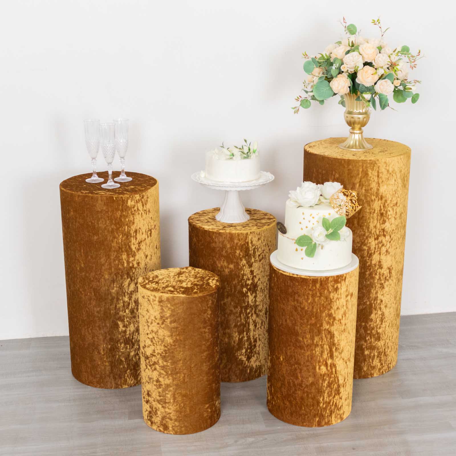 Gold velvet pedestal stand covers for elegant decor displays.
