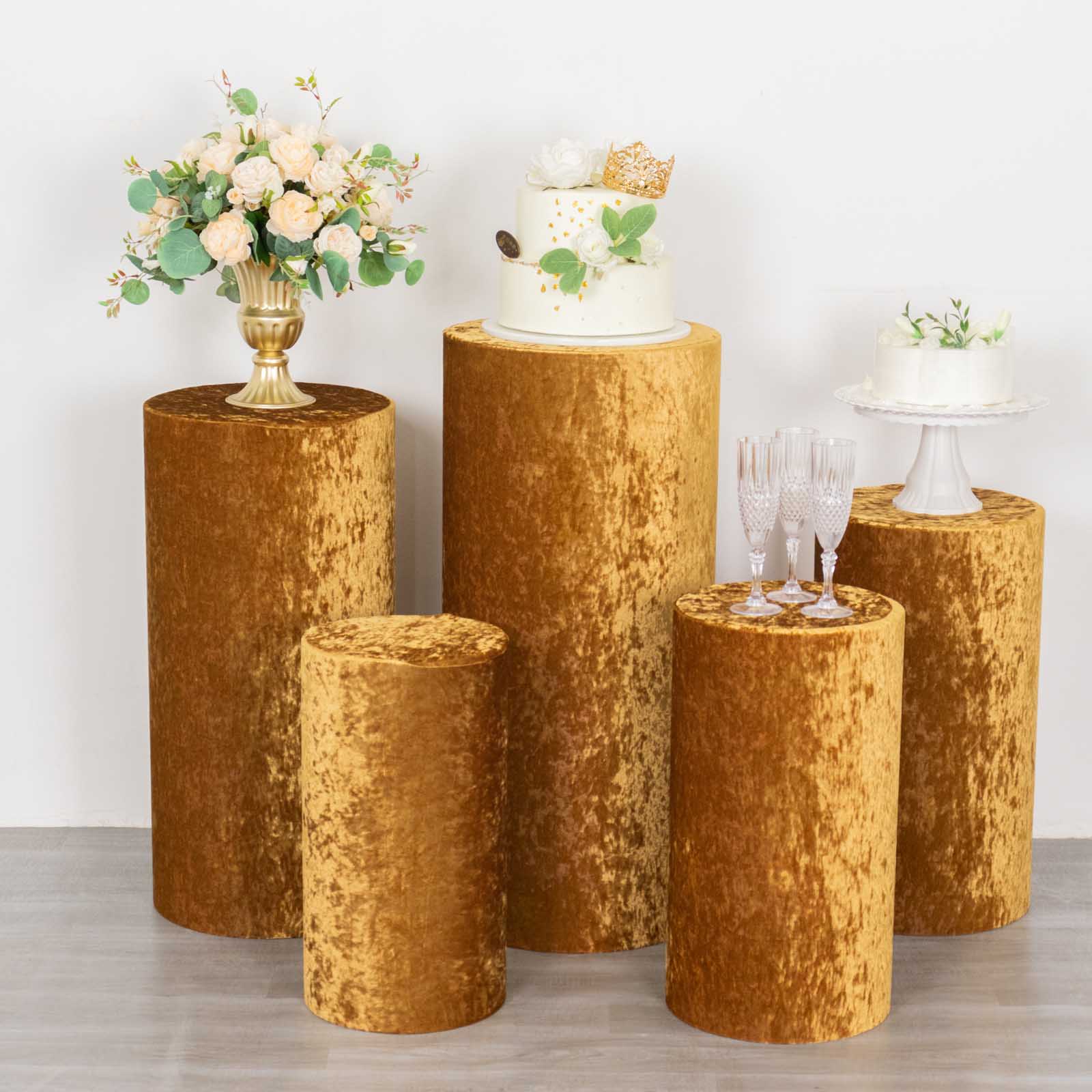 Gold crushed velvet pedestal stand covers with decorative displays.
