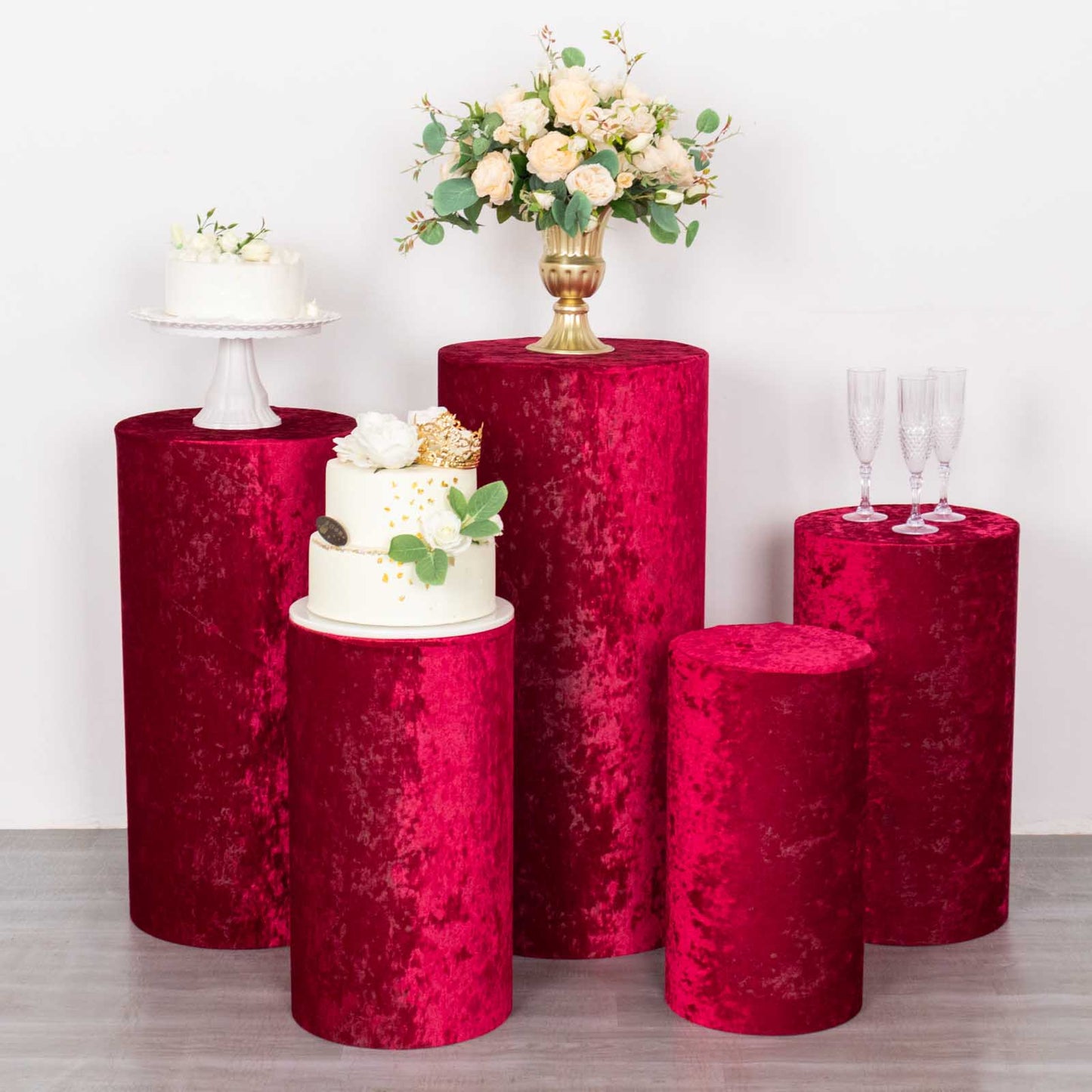 Set of 5 red crushed velvet pedestal stand covers for events and displays.