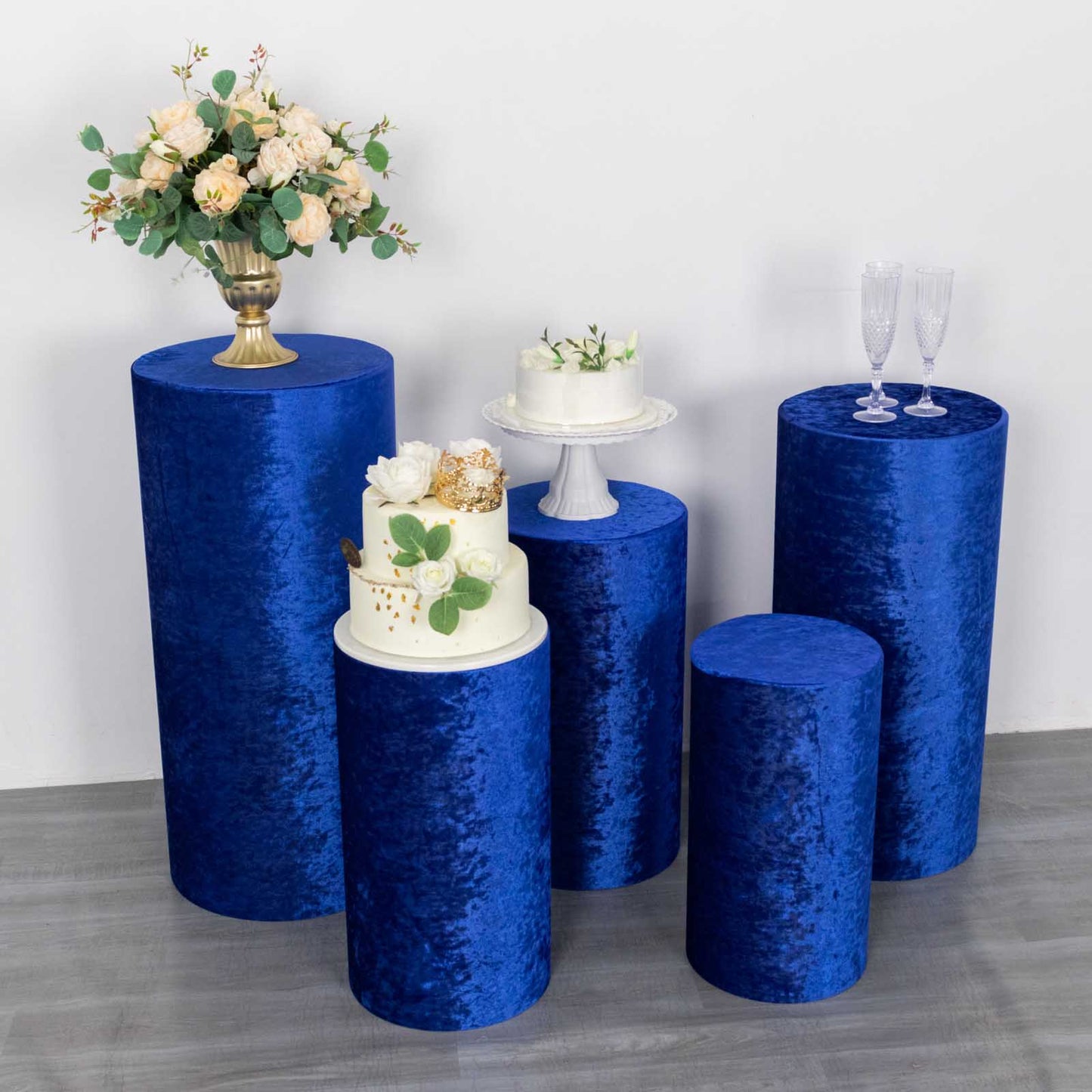 Royal blue crushed velvet pedestal stand covers in a decorative display.