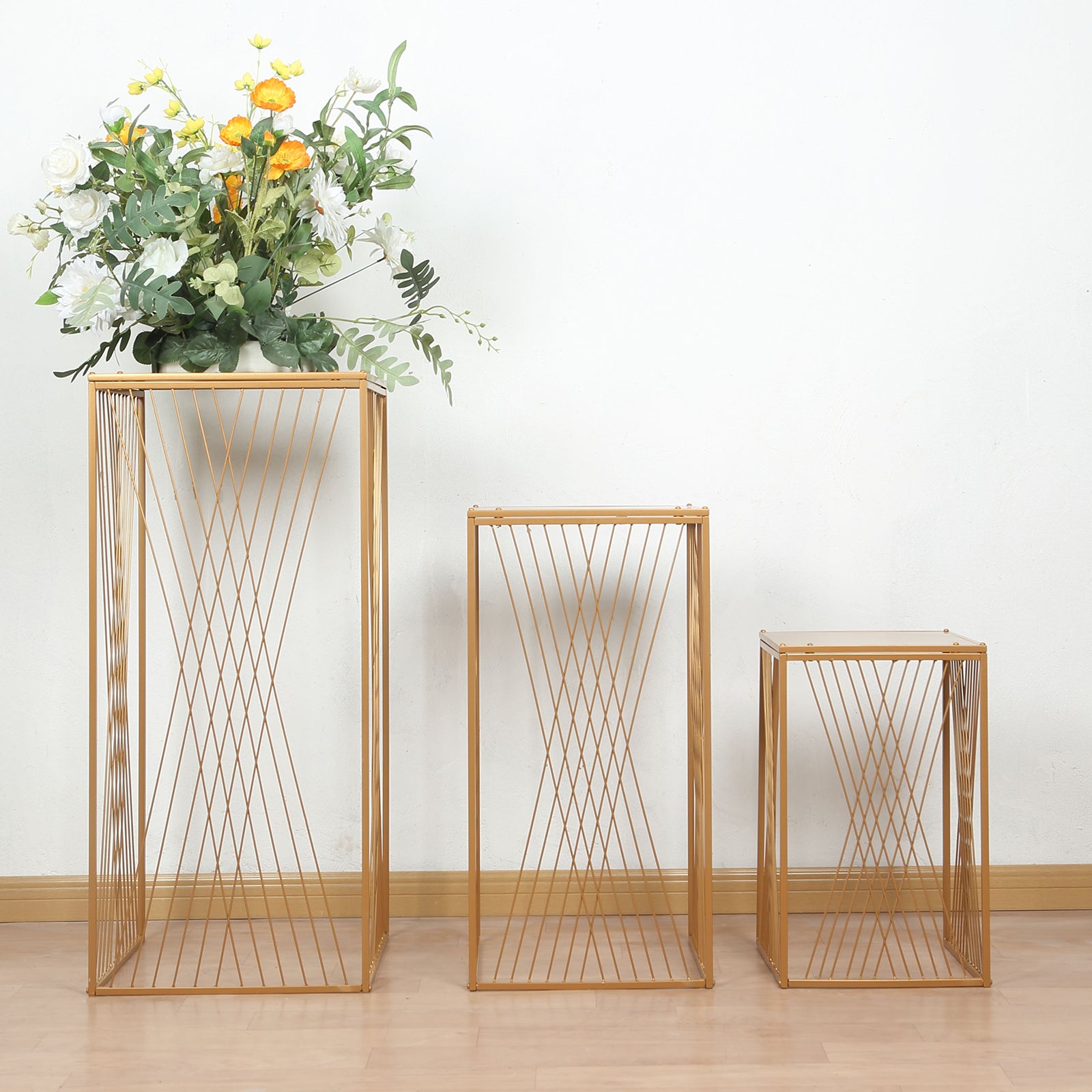 Gold metal rectangular plant stands with geometric pattern, ideal for floral displays.