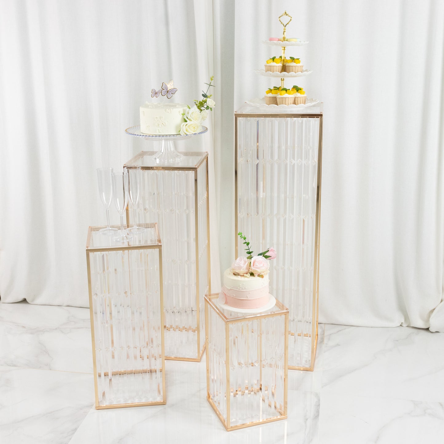 Gold metal pedestal stands set with acrylic tops and crystal pendants.