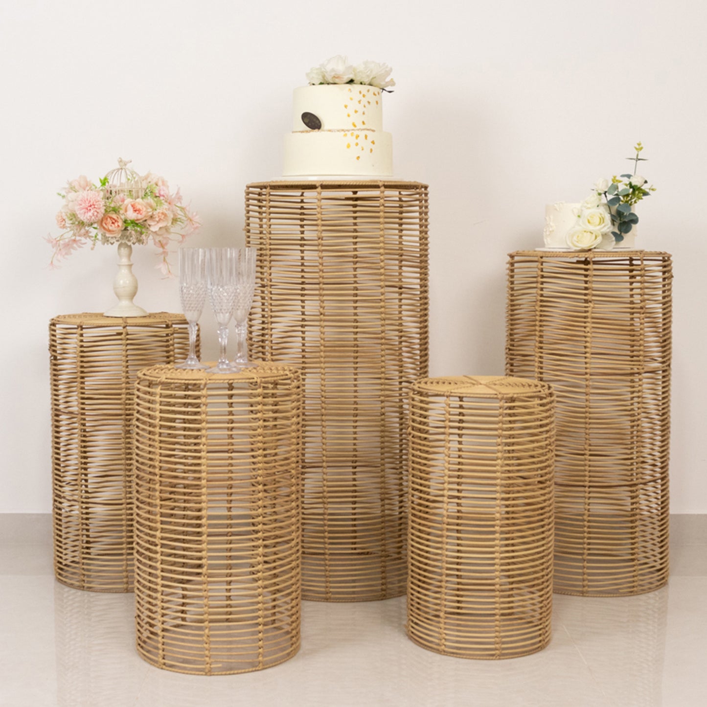 Natural woven rattan pedestal stands in various heights for display.