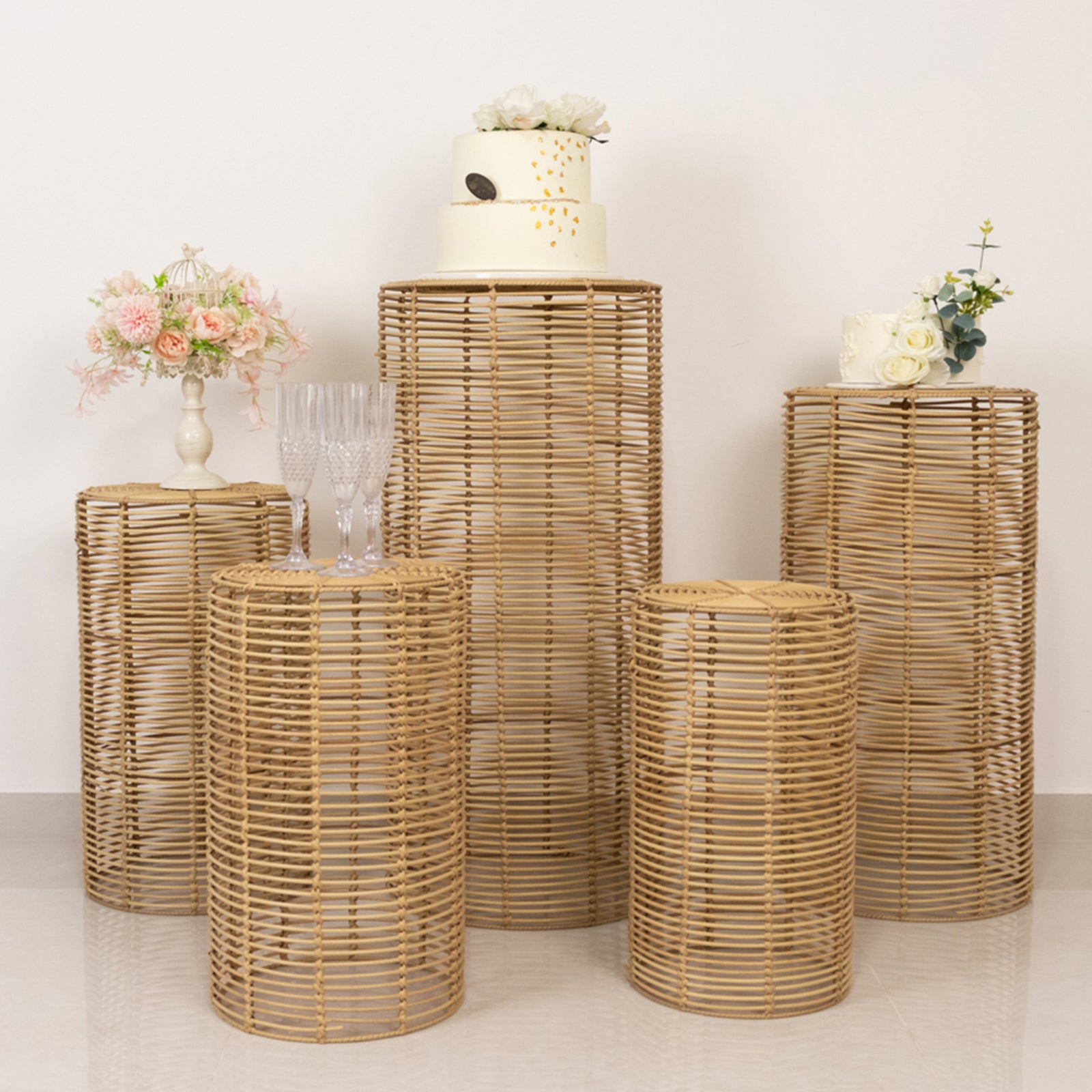 Natural woven rattan pedestal stands in various heights for display.