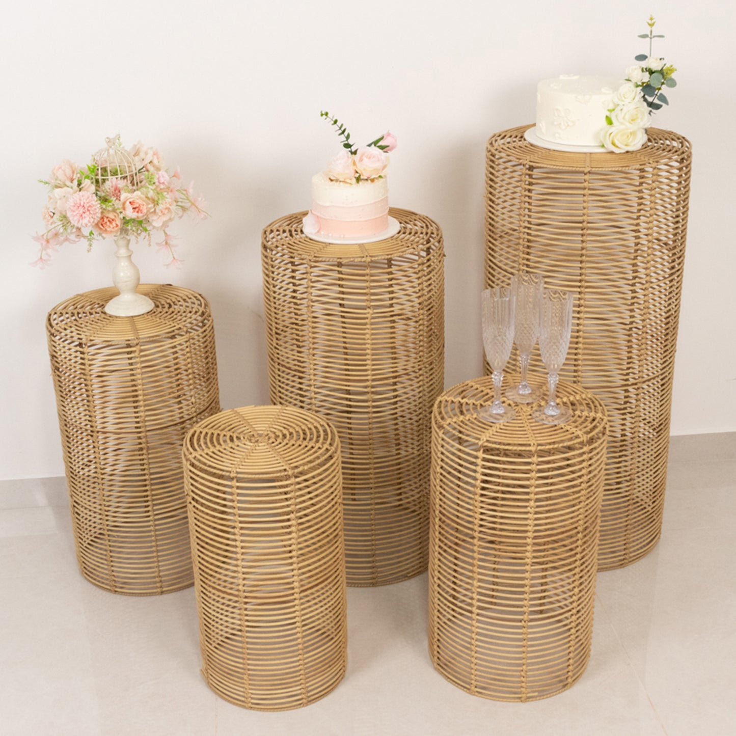 Natural woven rattan wicker pedestal stands in various heights for plant or dessert display.