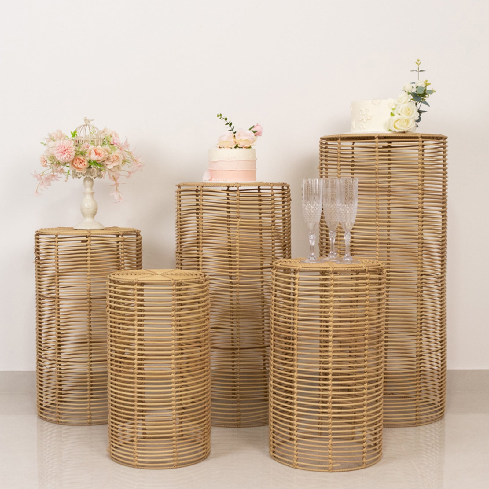 Natural woven rattan wicker pedestal stands in various sizes for display.