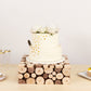 Natural wooden square riser with a white cake topped with flowers.