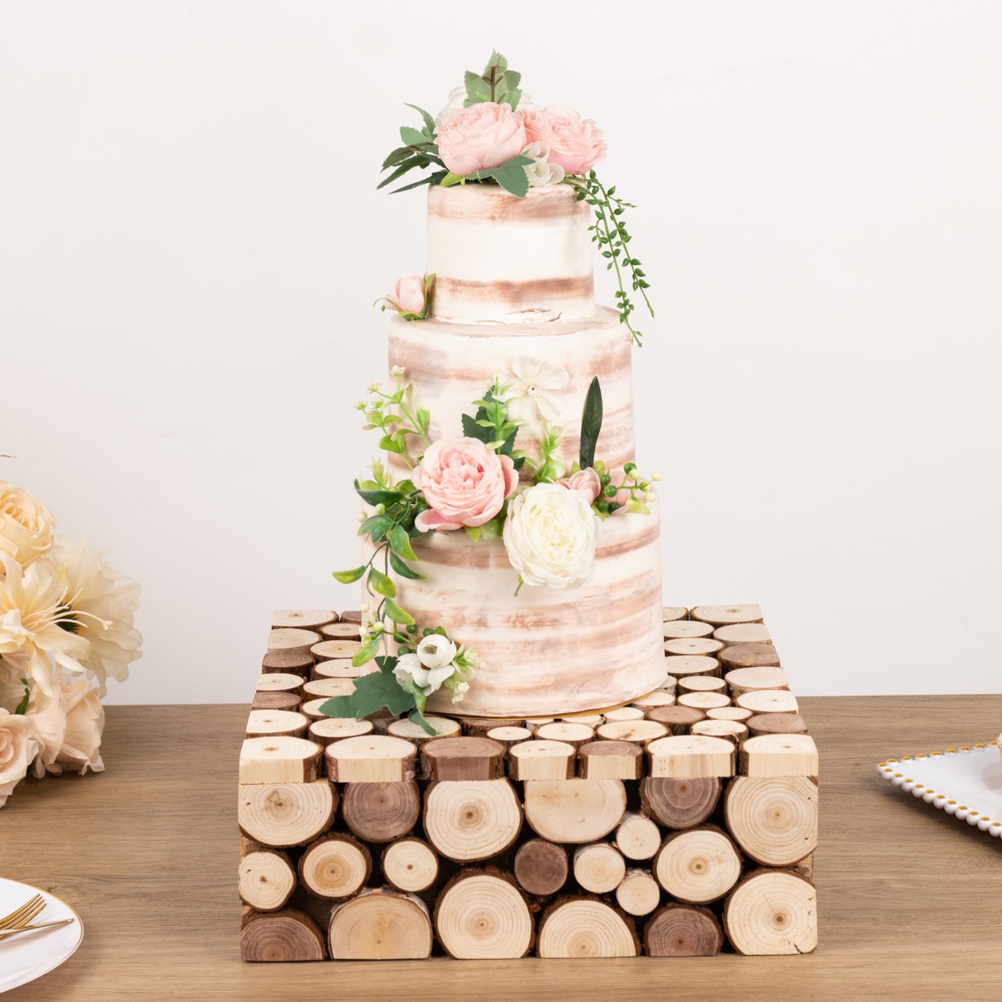 Natural wooden square pedestal riser for cake display with floral decoration.