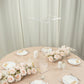 Clear acrylic flower pedestal stand on a table with pink floral decor.