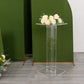 Clear acrylic flower pedestal stand with roses on top.