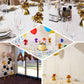 Metallic silver foil tassel top party balloon weights on a festive table.