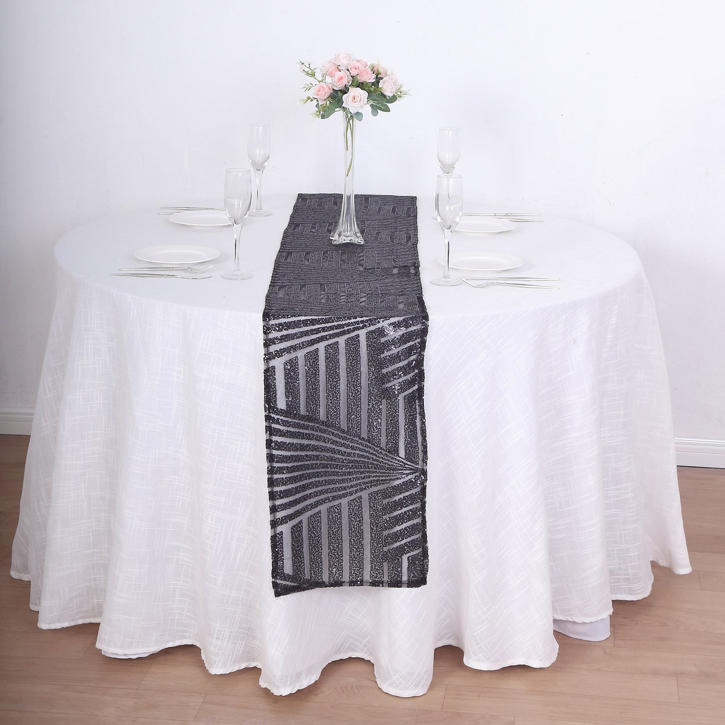 Black diamond glitz sequin table runner on a white tablecloth.