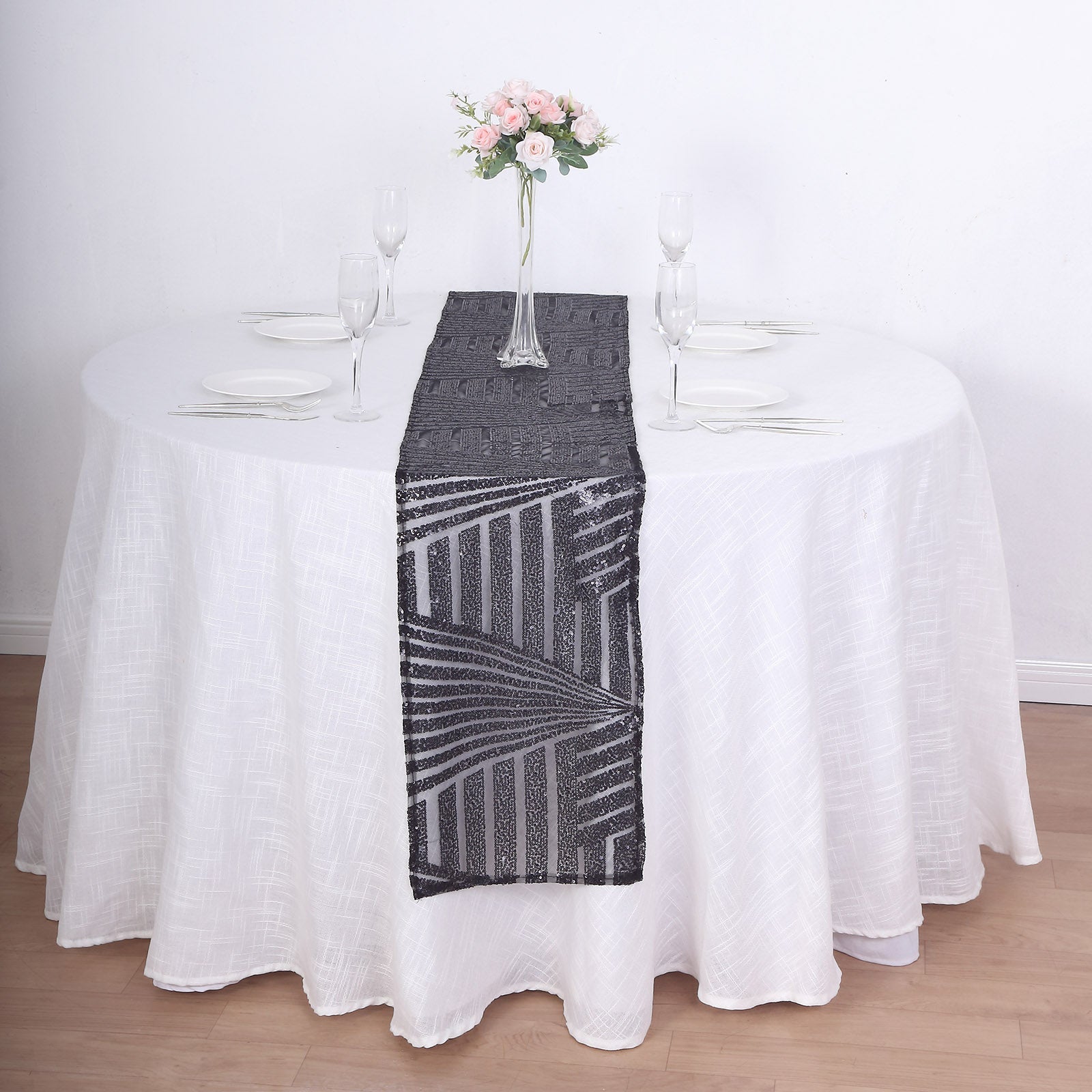 Black diamond glitz sequin table runner on a white tablecloth.