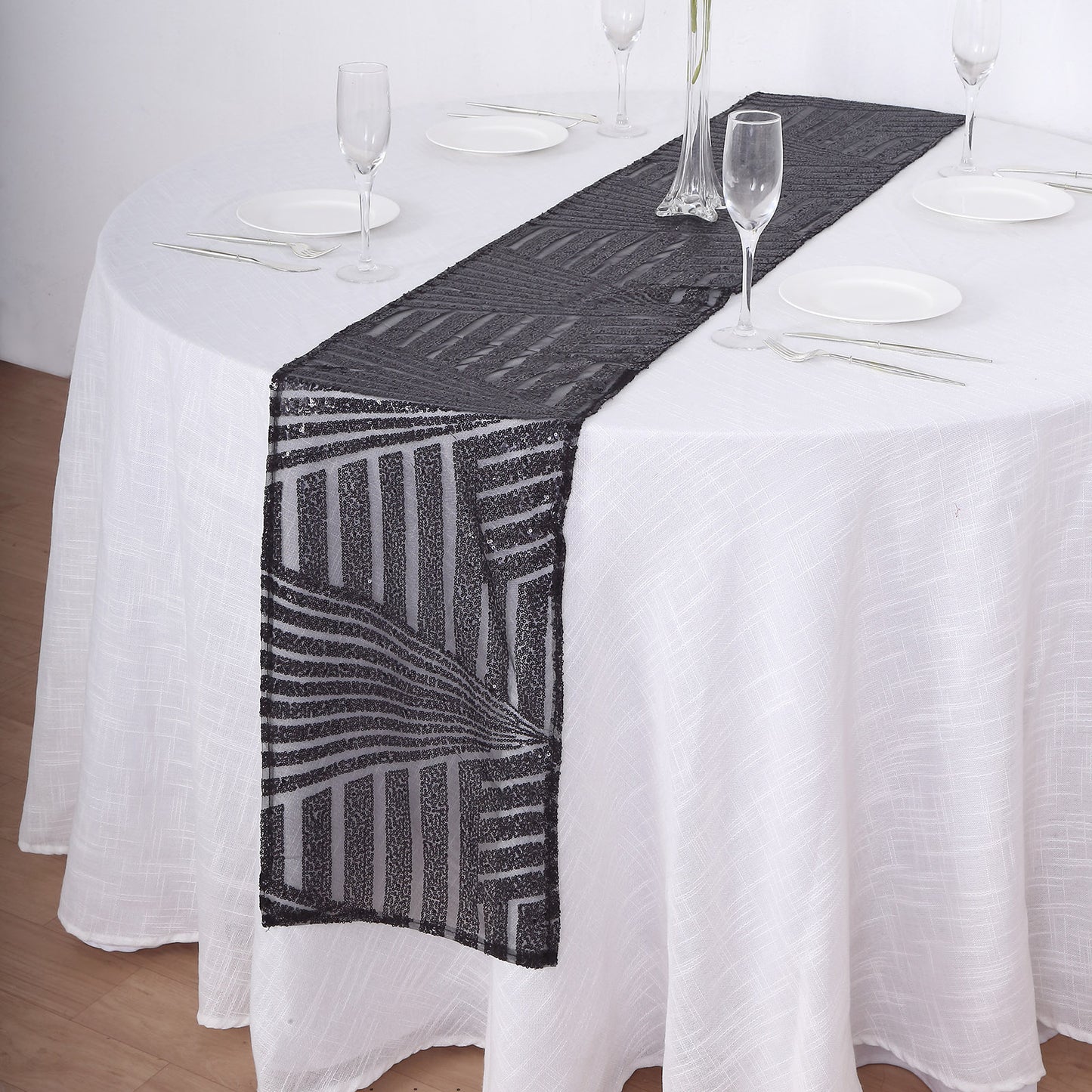 Black diamond glitz sequin table runner on a white tablecloth.