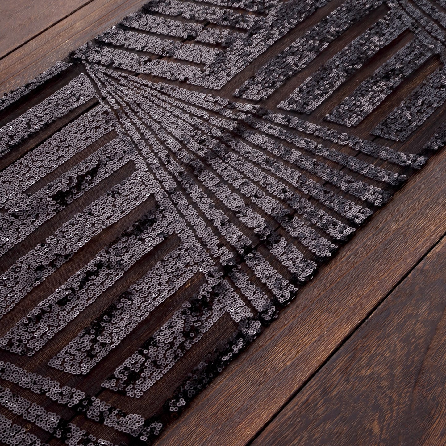 Black diamond glitz sequin table runner on a wooden surface.