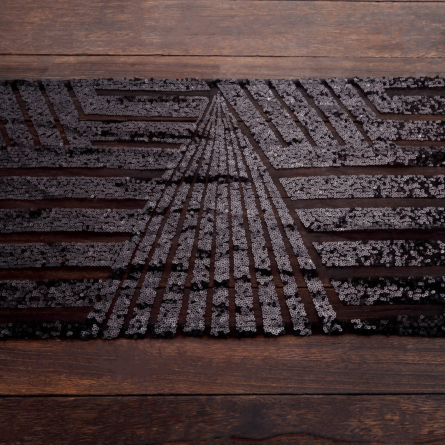 Black diamond glitz sequin table runner on a wooden surface.