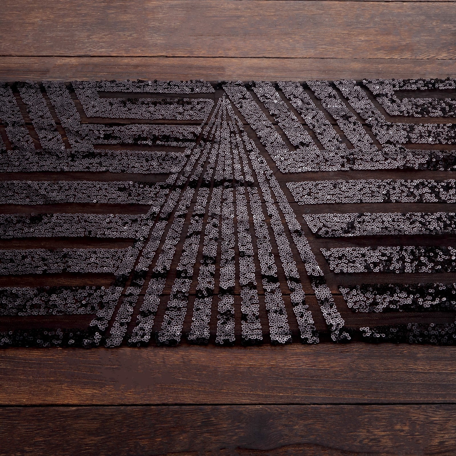Black diamond glitz sequin table runner on a wooden surface.