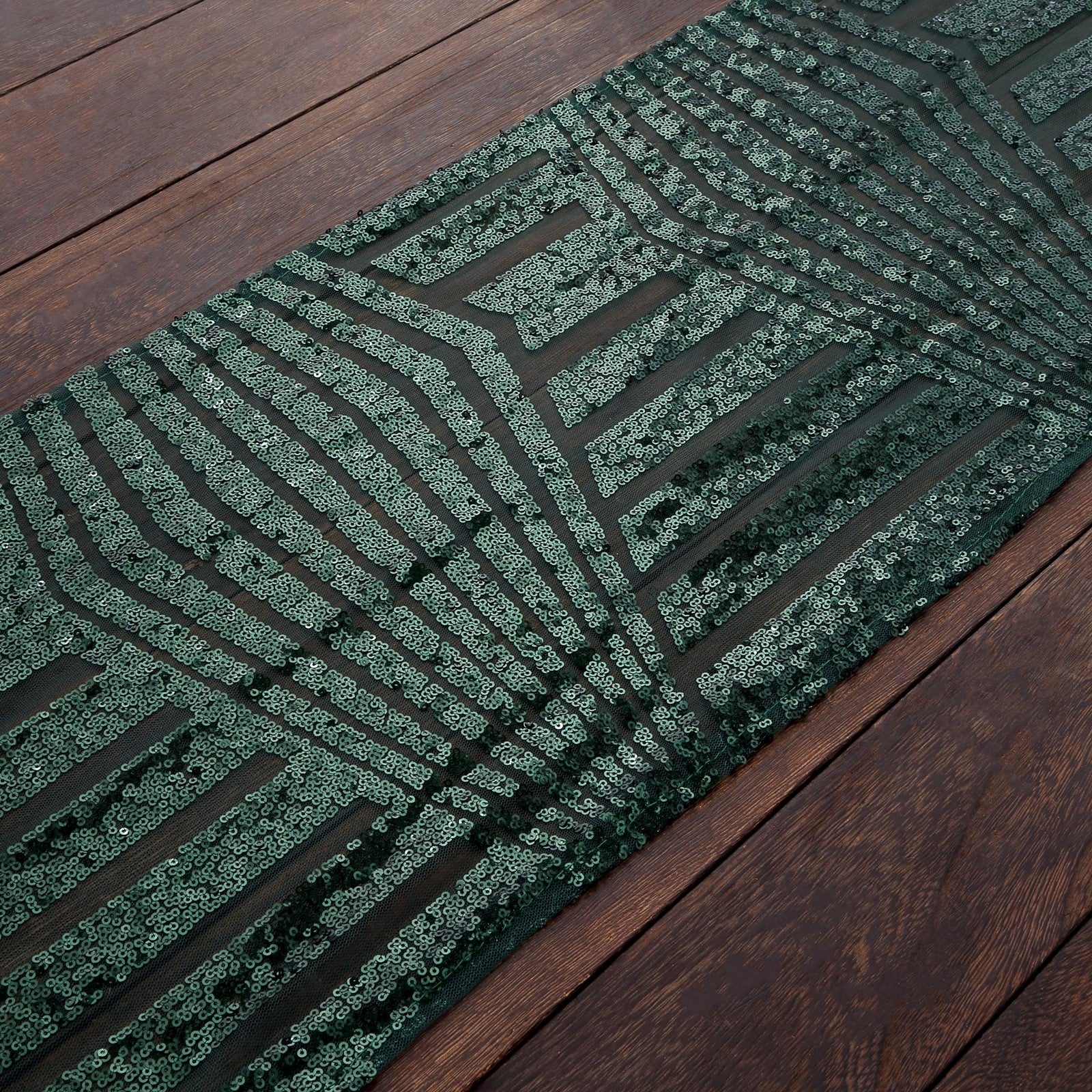 Hunter Emerald Green Sequin Table Runner on a wooden surface.
