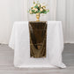 Shiny black gold foil table runner on a white table with flowers.