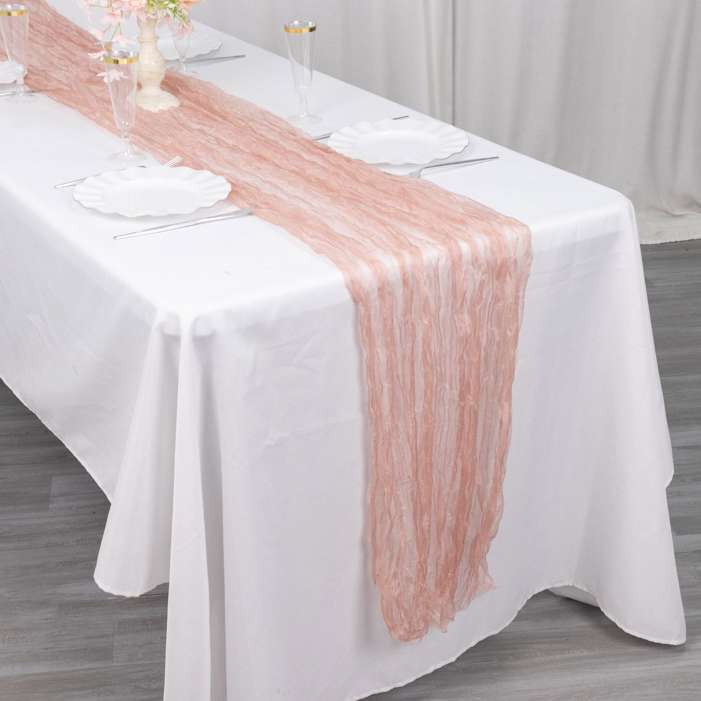 9ft dusty rose sheer crinkled organza table runner on a white table.