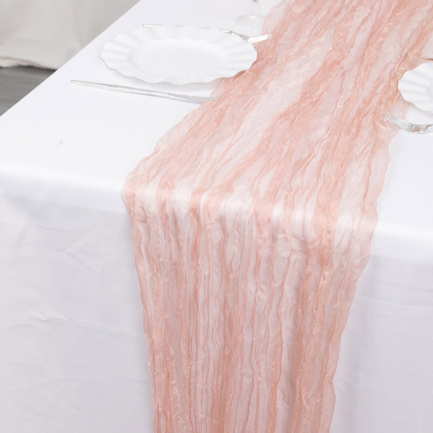9ft dusty rose sheer crinkled organza table runner on a white table.