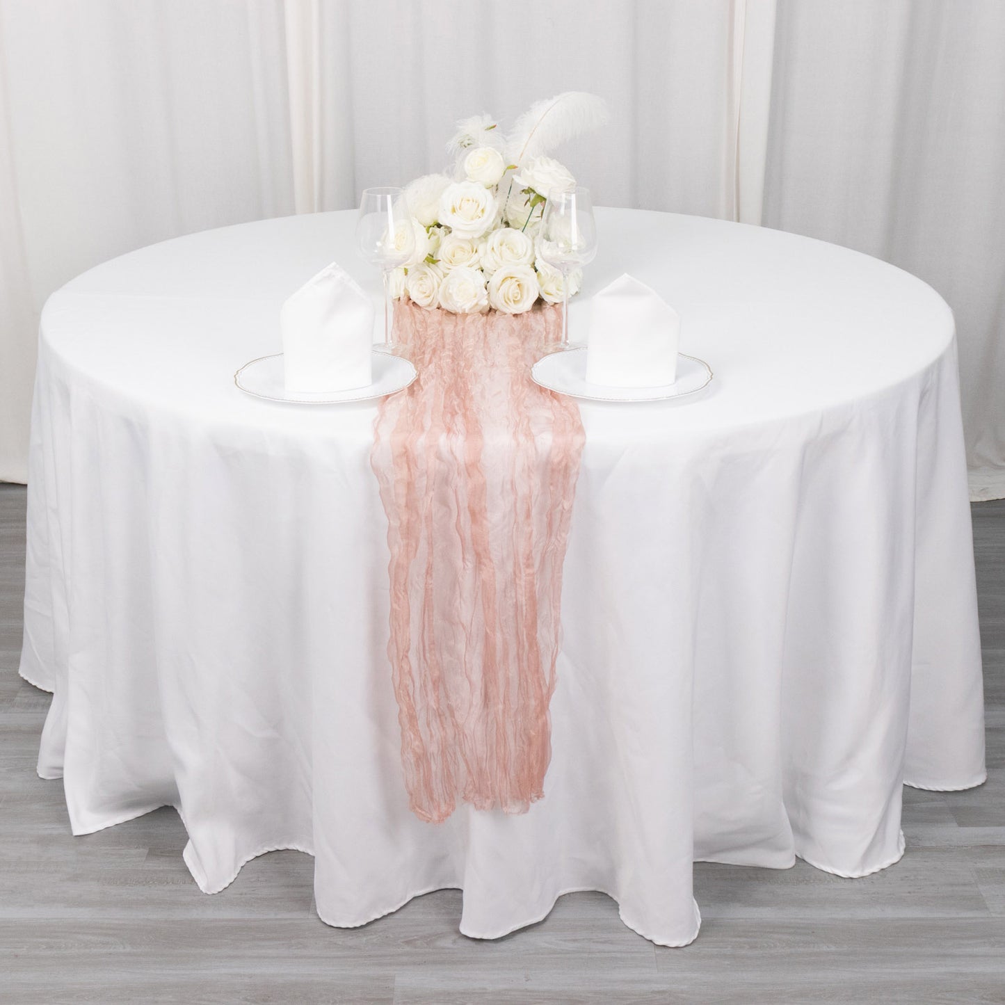 Dusty rose sheer crinkled organza table runner on a white table setting.
