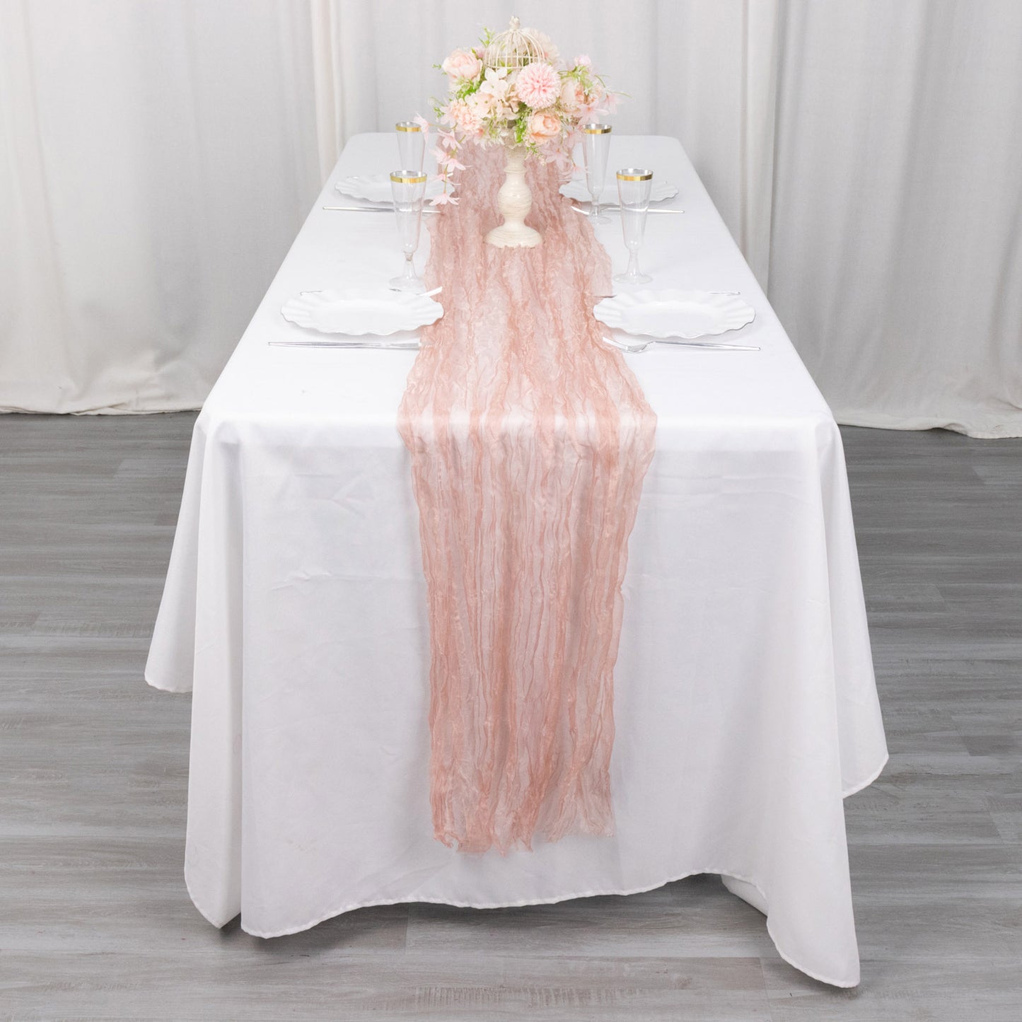 9ft dusty rose sheer crinkled organza table runner on a white table.