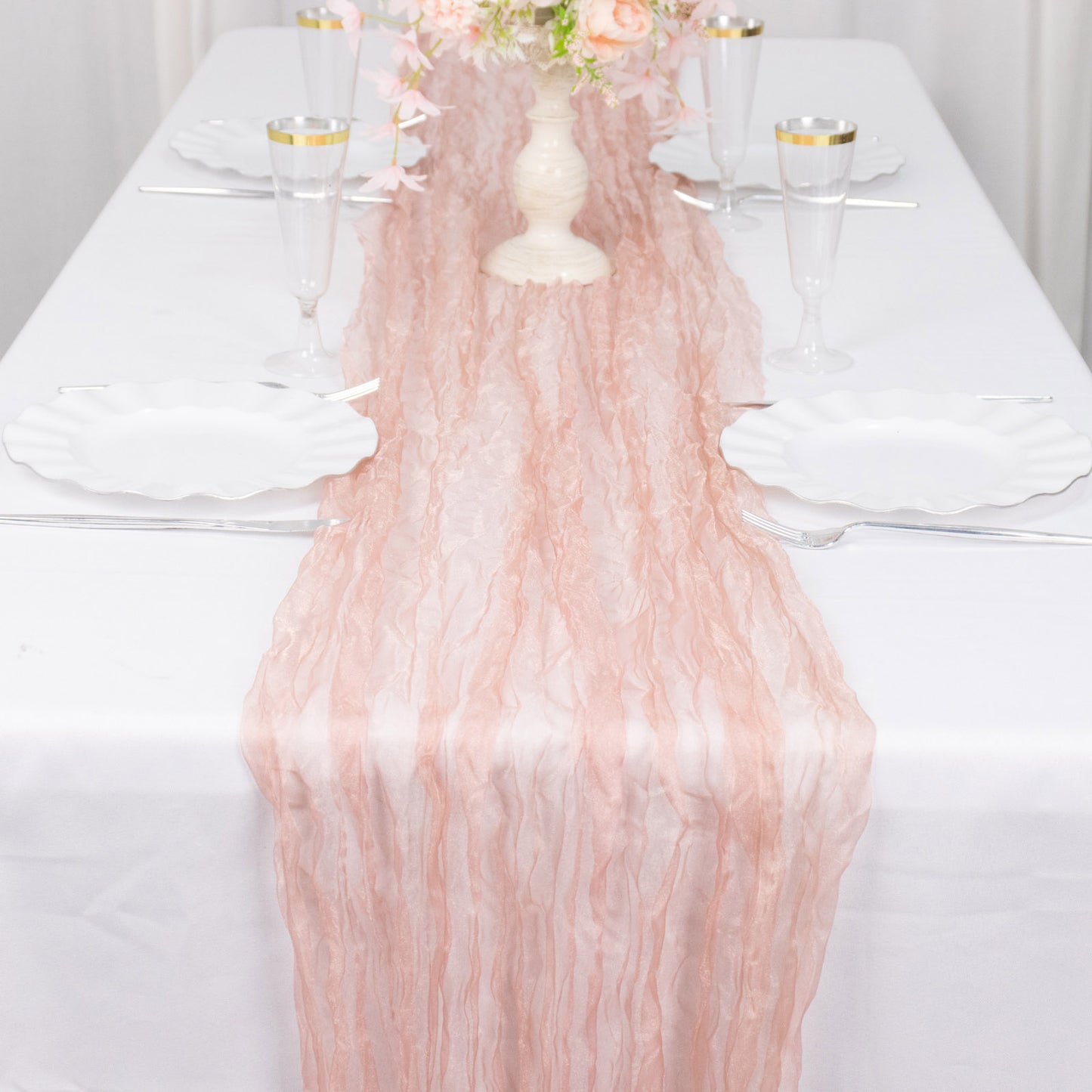 9ft dusty rose sheer crinkled organza table runner on a white table.