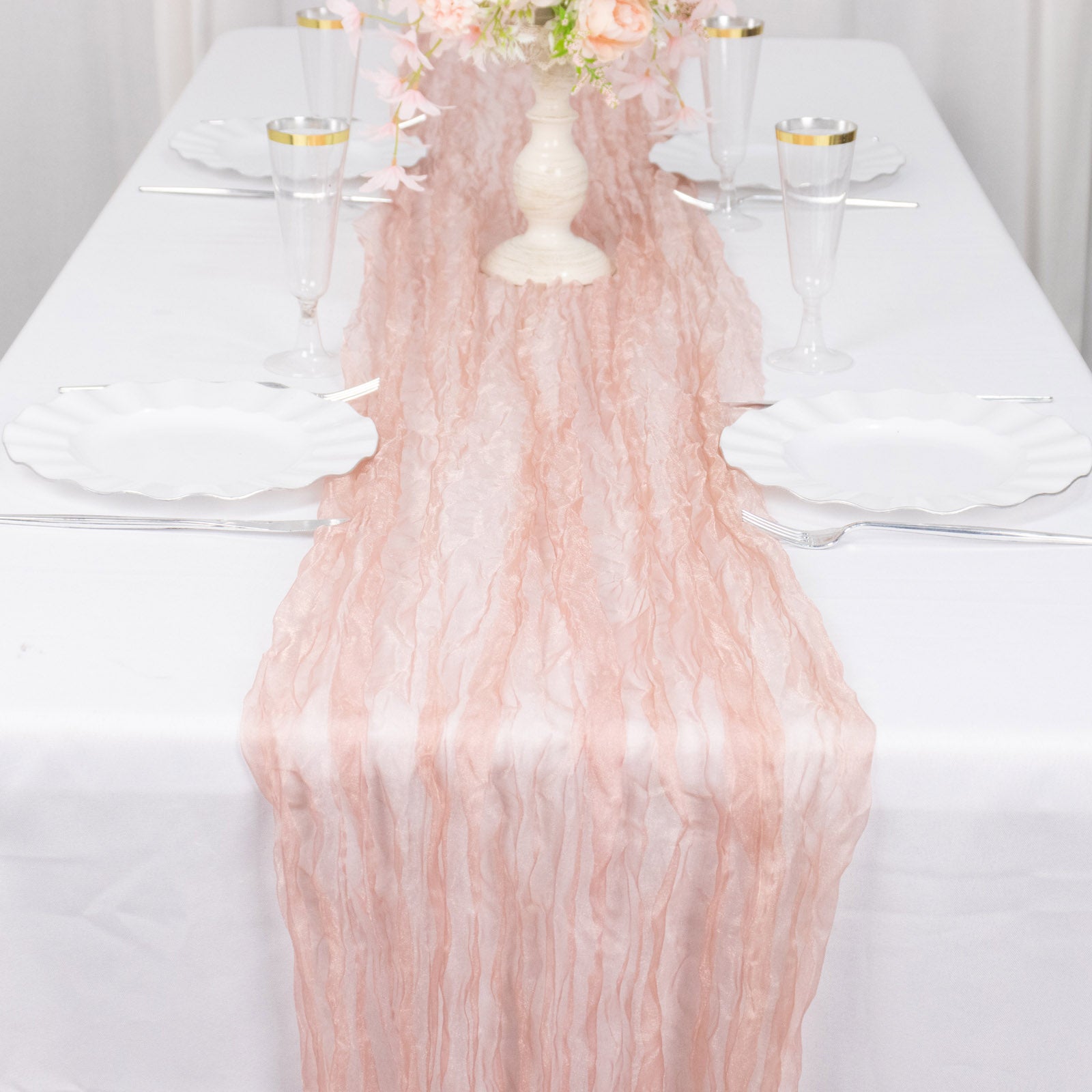 9ft dusty rose sheer crinkled organza table runner on a white table.