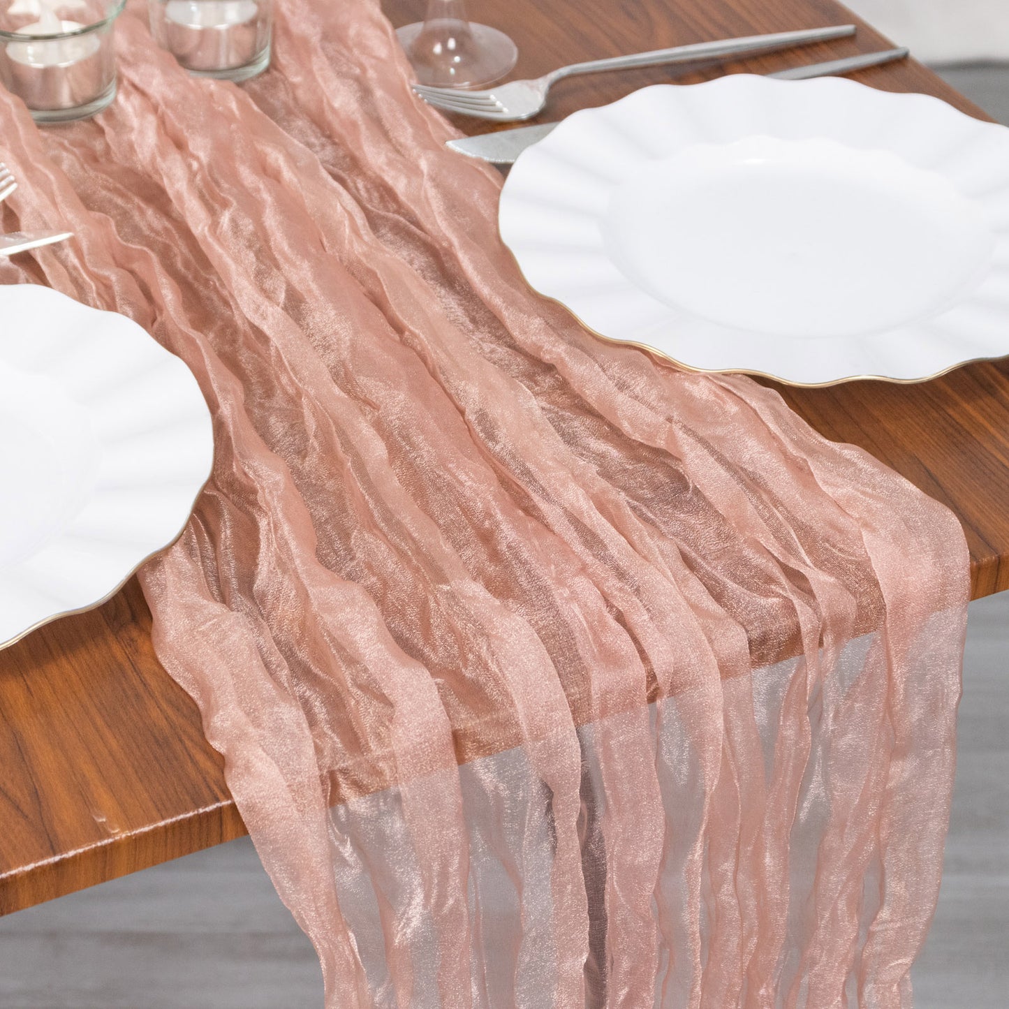 9ft Dusty Rose Sheer Crinkled Organza Table Runner on a wooden table.