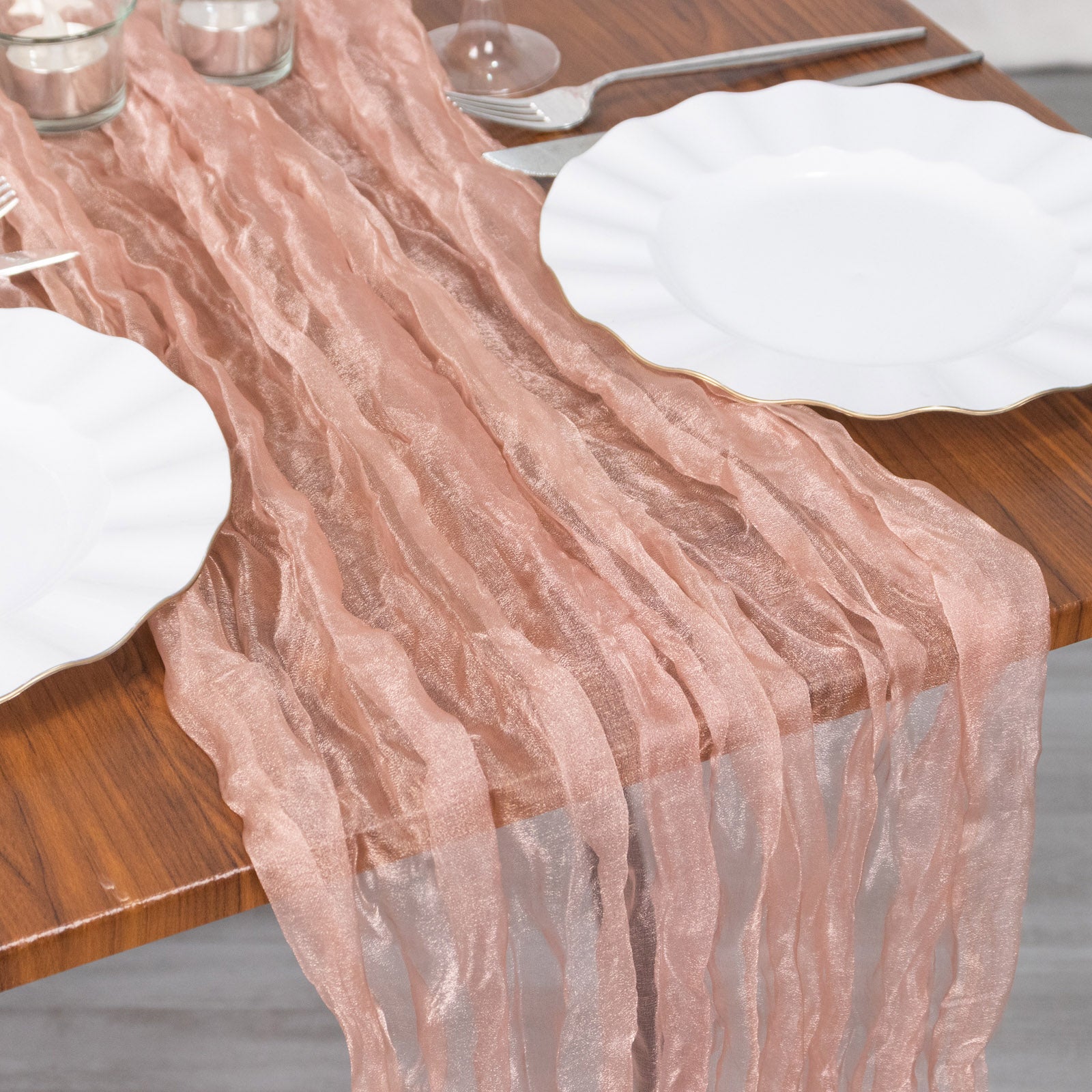 9ft Dusty Rose Sheer Crinkled Organza Table Runner on a wooden table.