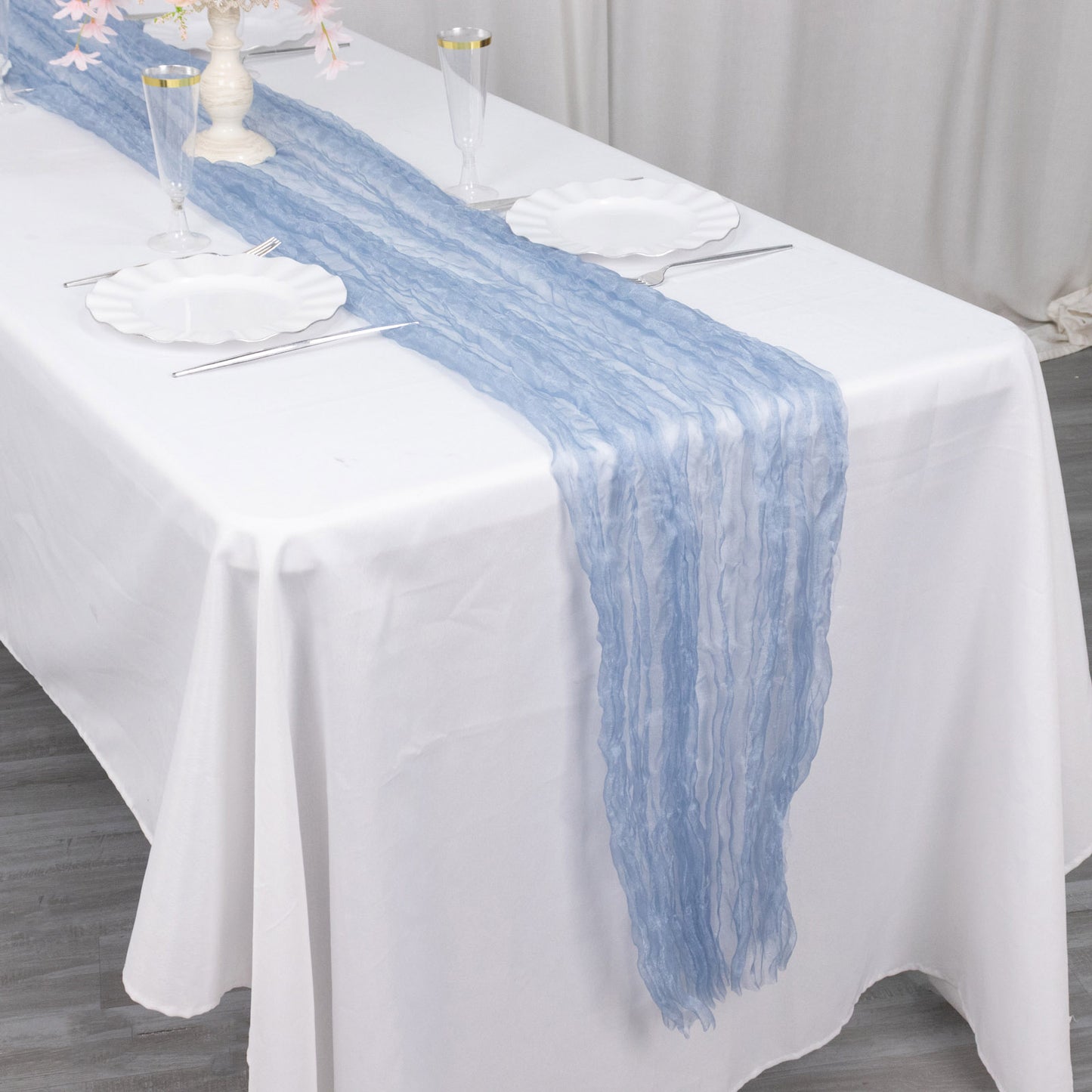 9ft Dusty Blue Sheer Crinkled Organza Table Runner on a white table.